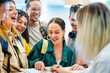 © Nicolas Micolani - Group of young people check in hotel at reception desk- Happy tourists students with hostel concierge looking map for summer vacation- Youth and Lifes style holiday concept