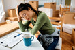 © Drazen - Exhausted Asian woman going through to do list while relocating into new home.
