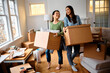 Young happy women have fun while moving into their new home.