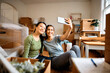 © Drazen - Happy female friends taking selfie after moving into new apartment.