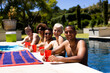 © WavebreakMediaMicro - Portrait of happy diverse group of friends having pool party, holding plastic cups in garden