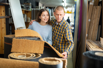 Wall Mural - Couple of positive customers holding flooring samples in hardware store