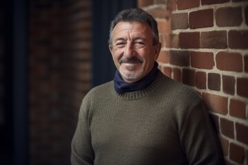 Poster - Portrait of a senior man in a room with a brick wall