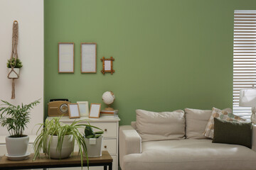 Poster - Comfortable sofa, houseplants and chest of drawers in cozy room. Interior design