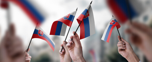 Wall Mural - A group of people holding small flags of the Slovakia in their hands