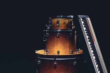 Wall Mural - Drums and musical keys on a black background isolated.