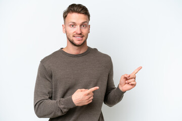 Wall Mural - Young blonde caucasian man isolated on white background frightened and pointing to the side