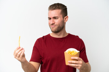 Poster - Young caucasian man holding fries potatoes isolated on white background