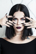 Portrait of beautiful brunette woman with black nails, halloween character