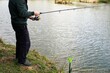 Angler am Teichufer beim Angeln am Morgen im Frühling
