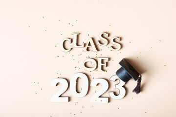 Canvas Print - Class of 2023 concept. Wooden number 2023 with graduated cap on colored background.