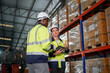 © FotoArtist - Multiethnic industrial workers checking their logistic lists while working with transportation of goods in warehouse