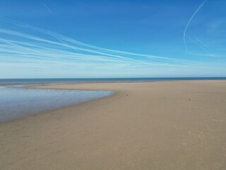 Poster - Aerial view of golden sand beach with low tide and blue sky background. Taken in Lytham Lancashire England. 