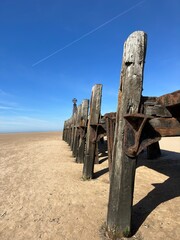 Wall Mural - Old wooden pier On St Anne's beach in Lytham Lancashire England. Blue sky background and no people. 