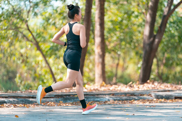 Asian woman in good shape jogging in the park in the summer