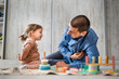 © Sandra - One man caucasian playing at home with his daughter toddler on the floor with wooden toys, modern parenthood   lifestyle single parent concept