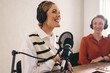 © Jacob Lund - Happy female podcaster presenting a guest on her show