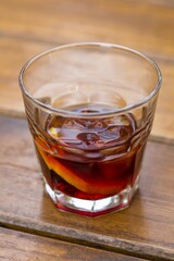 Poster - Vertical shot of a glass of alcoholic drink on a wooden surface