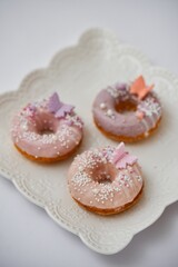 Canvas Print - Vertical closeup of creamy donuts with sprinkles and candy butterflies