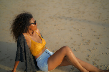 Wall Mural - African woman sit on the beach. Portrait sexy African lady travel ping and relaxing in the summer with tropical nature.