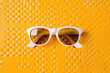 © ADDICTIVE STOCK - White sunglasses on a yellow background. Generative AI