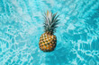 © ADDICTIVE STOCK - A pineapple floating on the water of a pool. Generative AI
