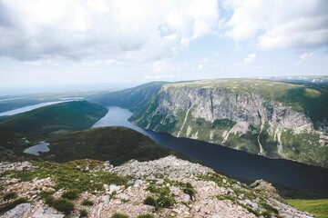 Beautiful view of river between mountains under blue cloudy sky in Gros Morne National Park