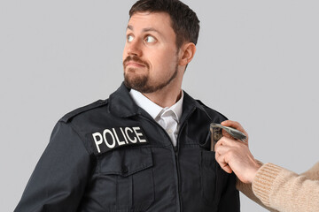 Canvas Print - Mature man giving bribe to policeman on grey background