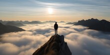 One Man Standing On Mountain Peak Over The Clouds .