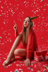 Poster - Drunk young woman with burning candle celebrating Birthday on red background