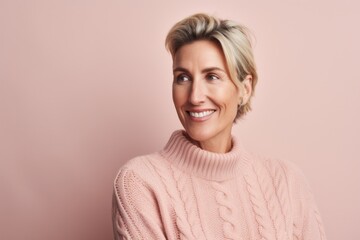 Wall Mural - Portrait of smiling mature woman in sweater looking away isolated on pink background
