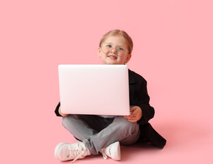 Wall Mural - Funny little businesswoman with laptop sitting on pink background