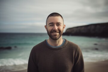 Wall Mural - Portrait of a handsome young man smiling at the camera on the beach