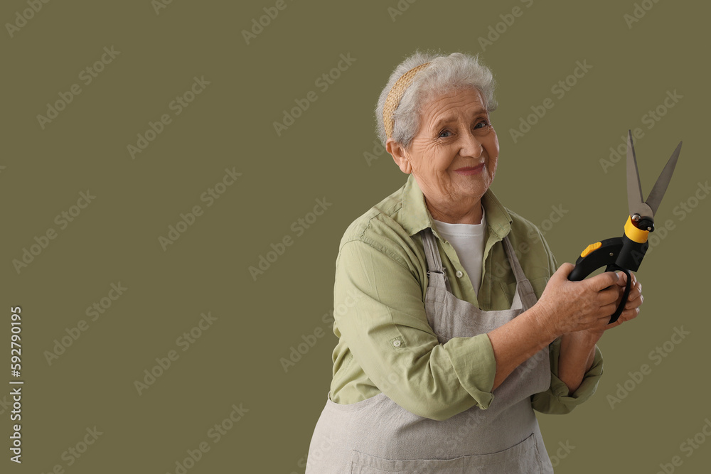 Senior gardener with secateurs on green background
