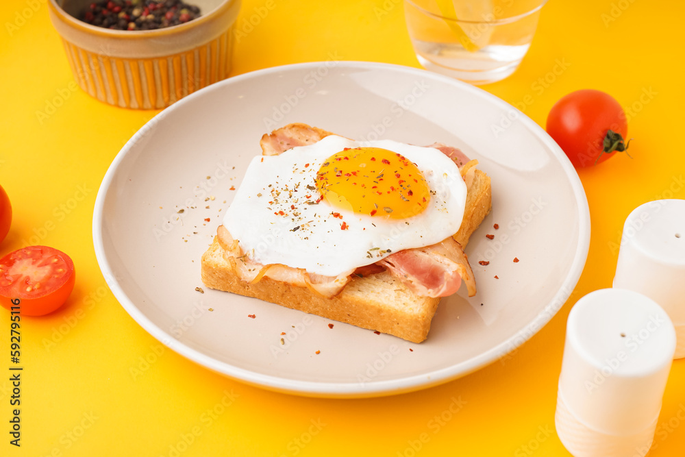 Delicious sandwich with fried egg and bacon on yellow background