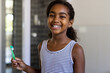 © Wavebreak Media - Portrait of happy biracial girl wearing striped dress and holding toothbrush and smiling in bathroom