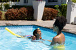 © Wavebreak Media - Happy biracial mother and daughter learning to swim with float in swimming pool in sunny garden