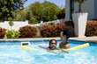 © Wavebreak Media - Happy biracial mother and daughter learning to swim with float in swimming pool in sunny garden