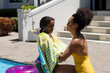 © Wavebreak Media - Happy biracial mother and daughter drying off with towel by swimming pool in the sun