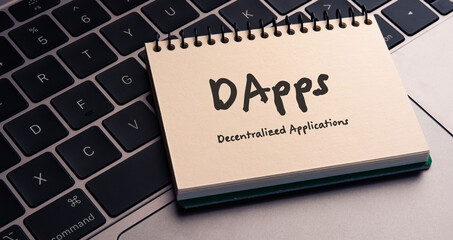 Poster - There is note book with the word Decentralized Applications on a laptop. It is an eye-catching image.