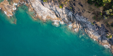 Wall Mural - top view of ocean and rock texture. Aerial view of sea and fantastic Rocky coast.