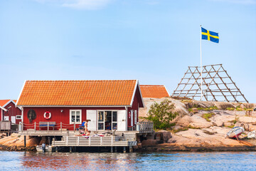 Canvas Print - Cottage with people by the sea at the swedish archipelago