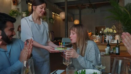 Poster - Waitress brings birthday positive girl cake and blows out candles to celebrate with friends in cafe