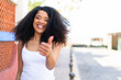 © luismolinero - Young African American woman at outdoors with thumbs up because something good has happened