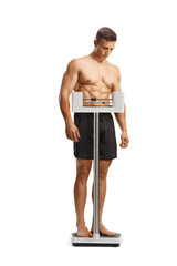 Sticker - Full length shot of a shirtless young man checking weight on a scale