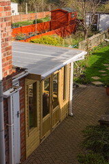 Flat-roofed extension to a house with back yard in the background