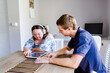 © Austockphoto - Teen wearing headphones talking with adult disability support worker in home office using tablet