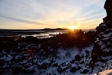 Sun rising over the hills by the sea with an icy foreground. Iceland.