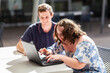 © Austockphoto - Young person who has down syndrome working with her disability worker NDIS provider on laptop