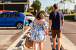 © Austockphoto - Sunlit young person carrying brown paper shopping bag walking down footpath in community